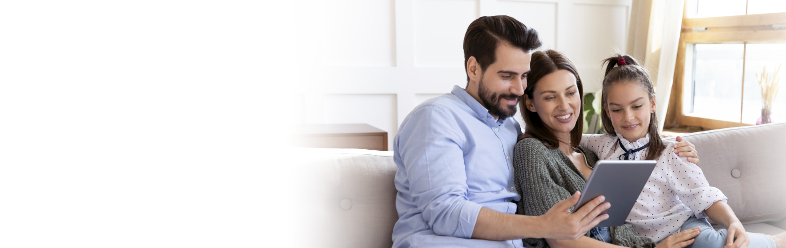 Hombre sonriendo junto a su familia navegando en internet Hombre sonriendo junto a su familia navegando en internet
